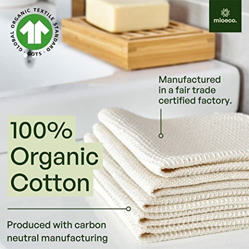 Stack of organic cotton towels with sustainability labels.