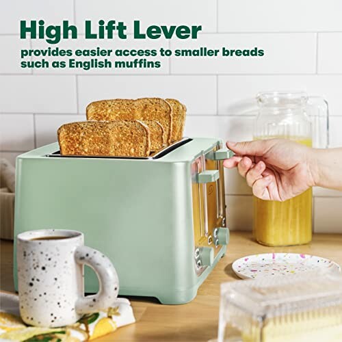 Hand using high lift lever on toaster with toasted bread.